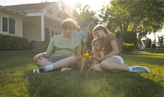 kids sitting on grass in fort worth